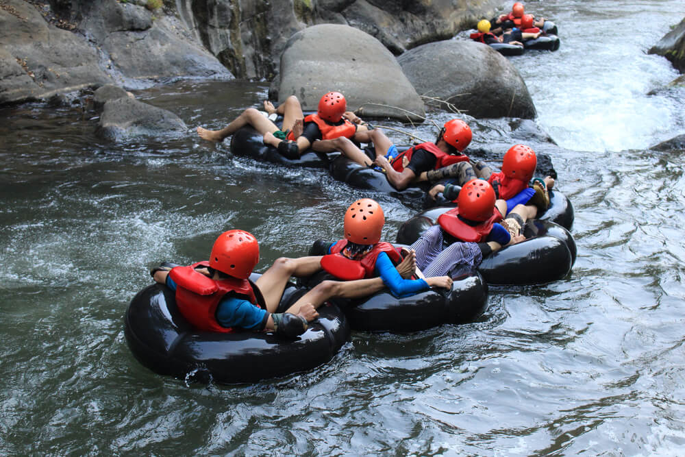 A group tubing down a mountain waterway in Kauai.